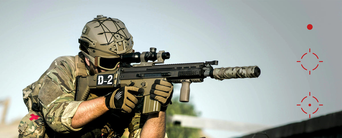 Person in military gear holding a rifle with a scope against a clear sky. reticle of red dot sight